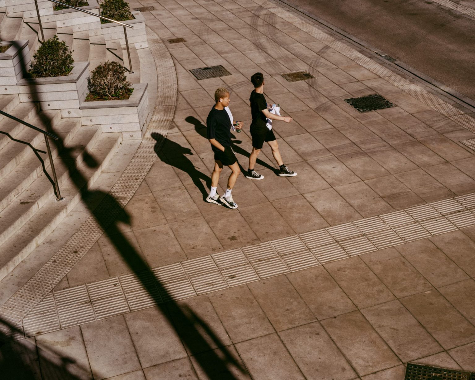 two men walking on a sidewalk