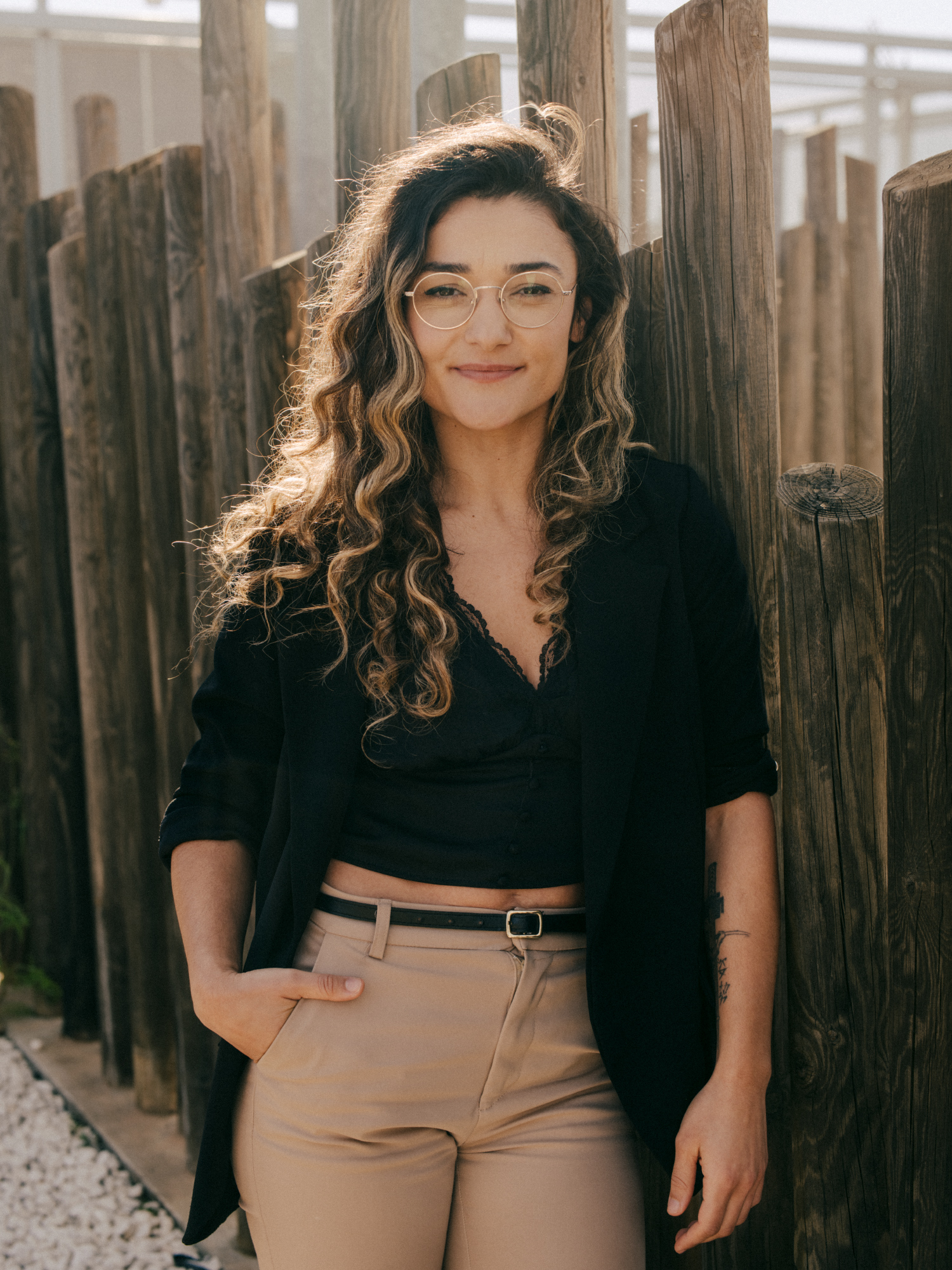 a woman standing in front of a fence