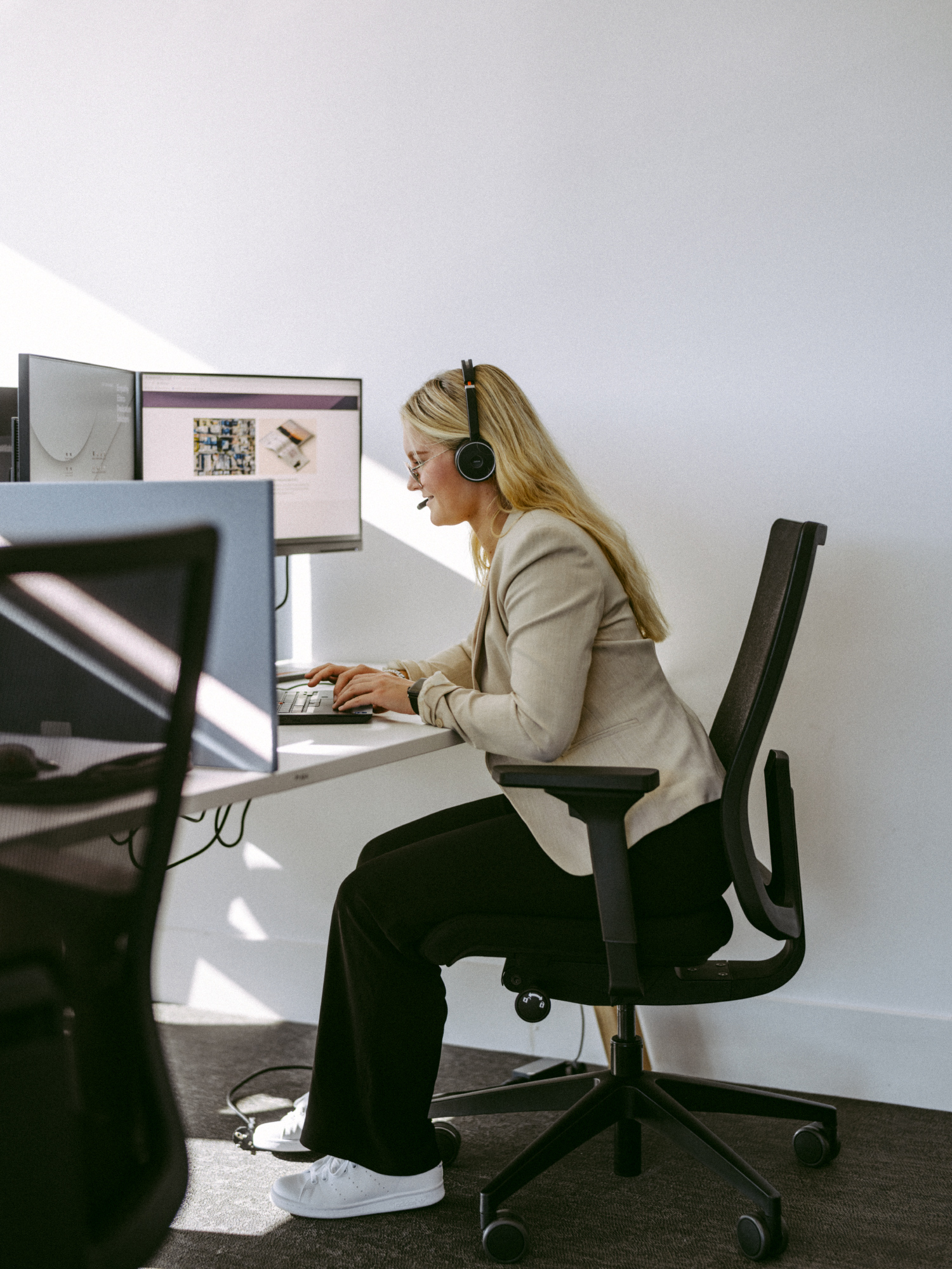 a woman sitting at a desk wearing headphones
