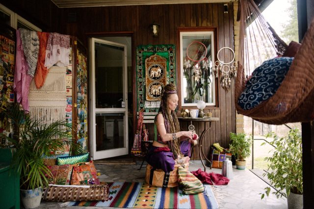 a woman sitting on a porch with a person holding a string
