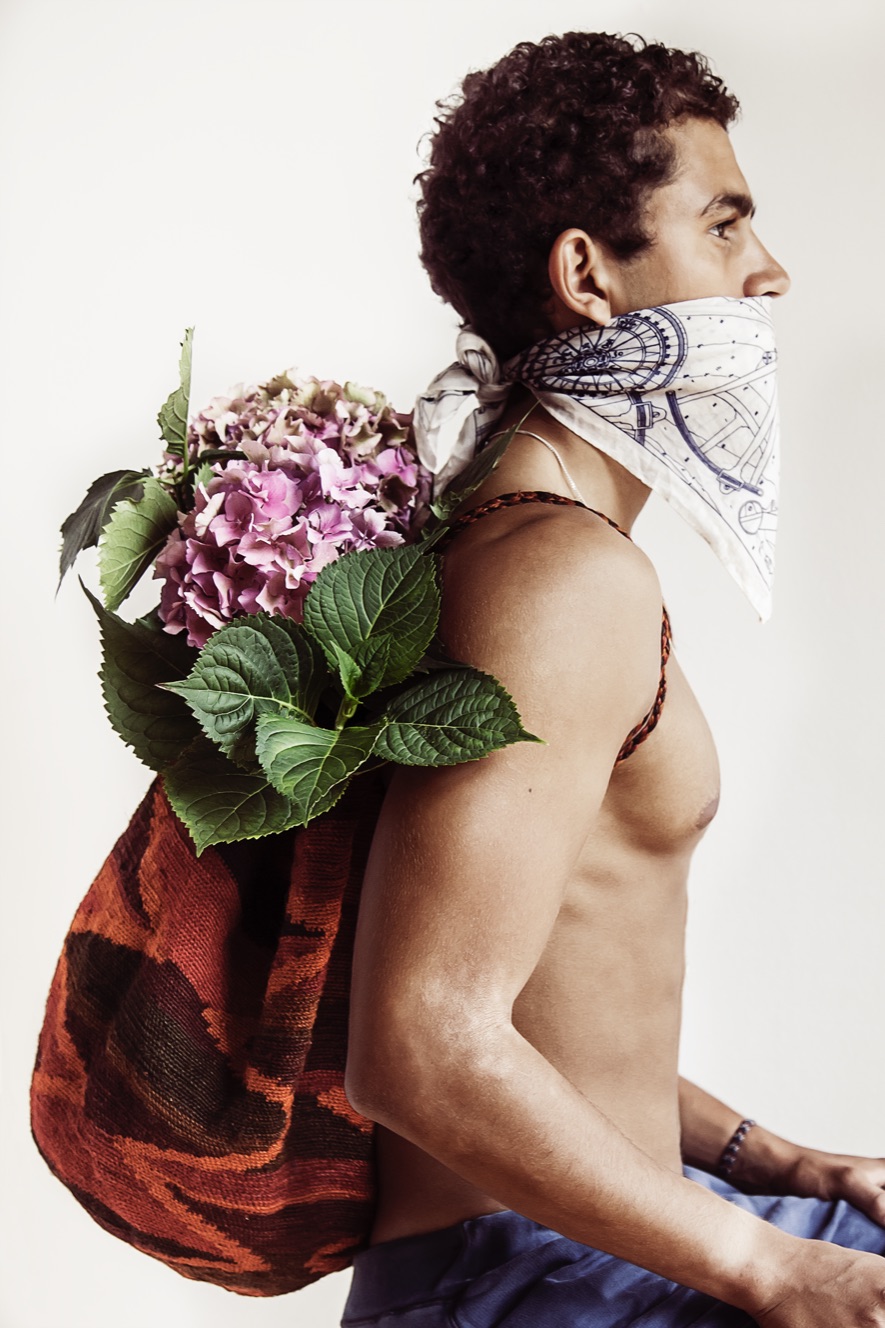 a man with a scarf over his mouth and flowers on his face