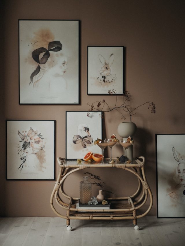 a table with drinks on it and a shelf with pictures on the wall