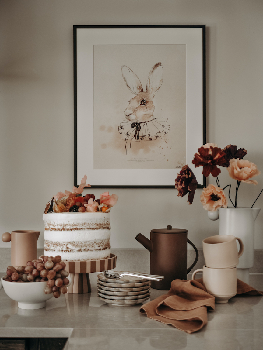 a table with a cake and flowers