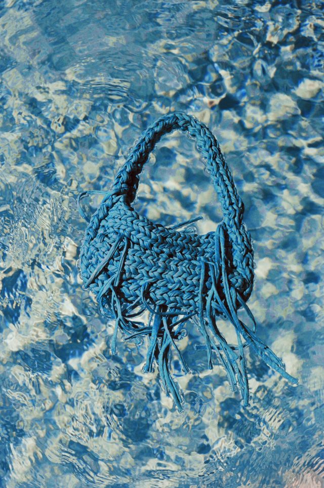 a blue knitted bag in water