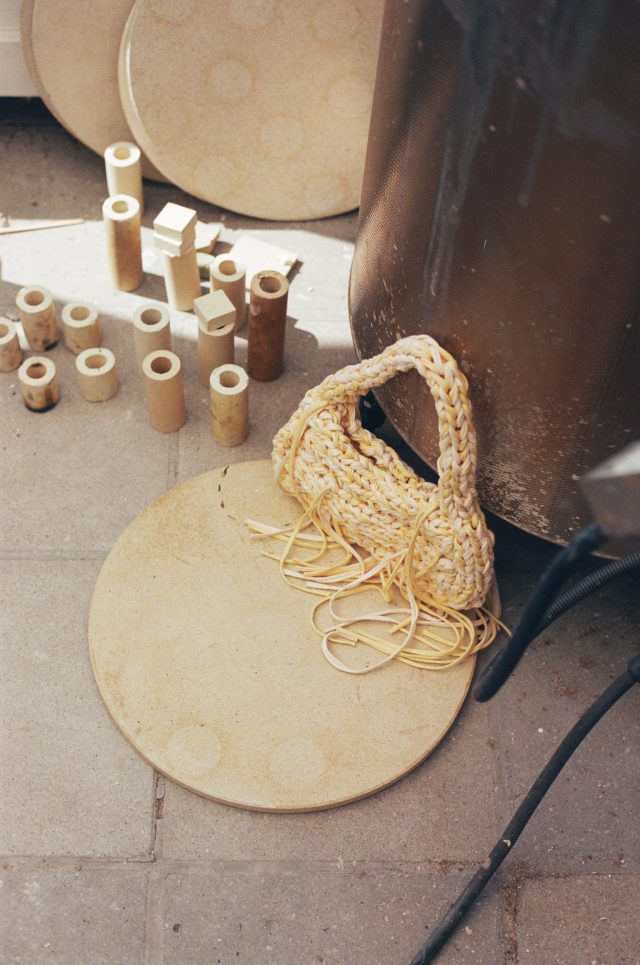 a basket and wood tubes next to a black cylinder