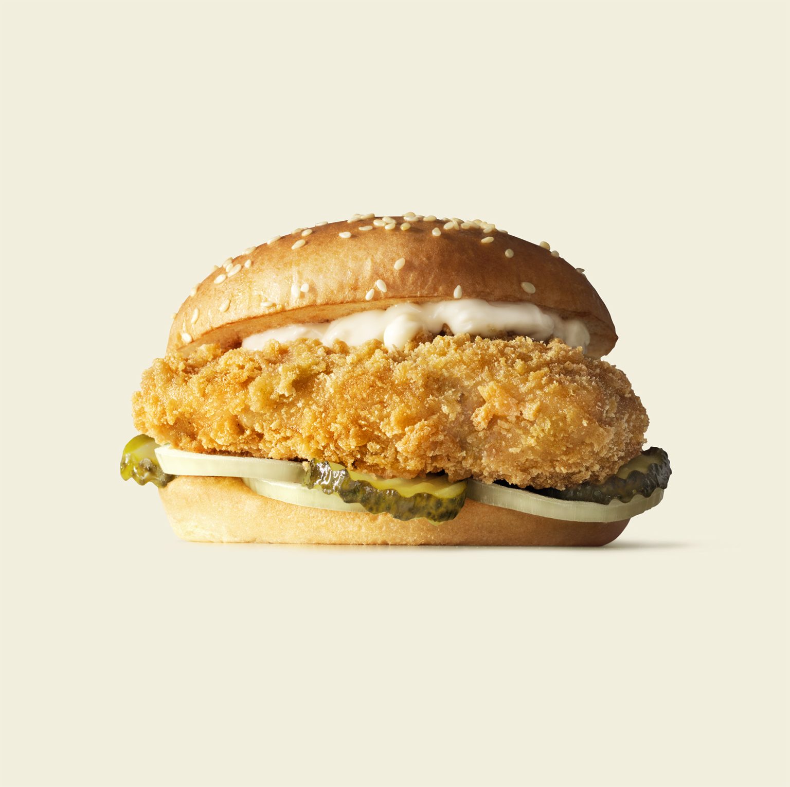 a chicken sandwich with pickles and mayonnaise
