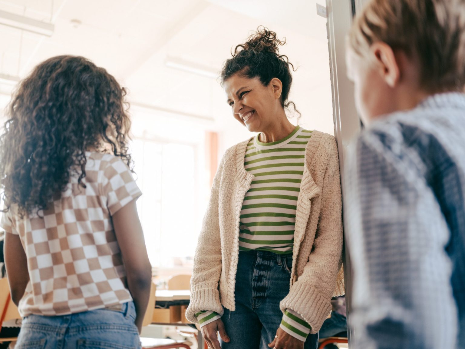 a woman smiling at a group of children