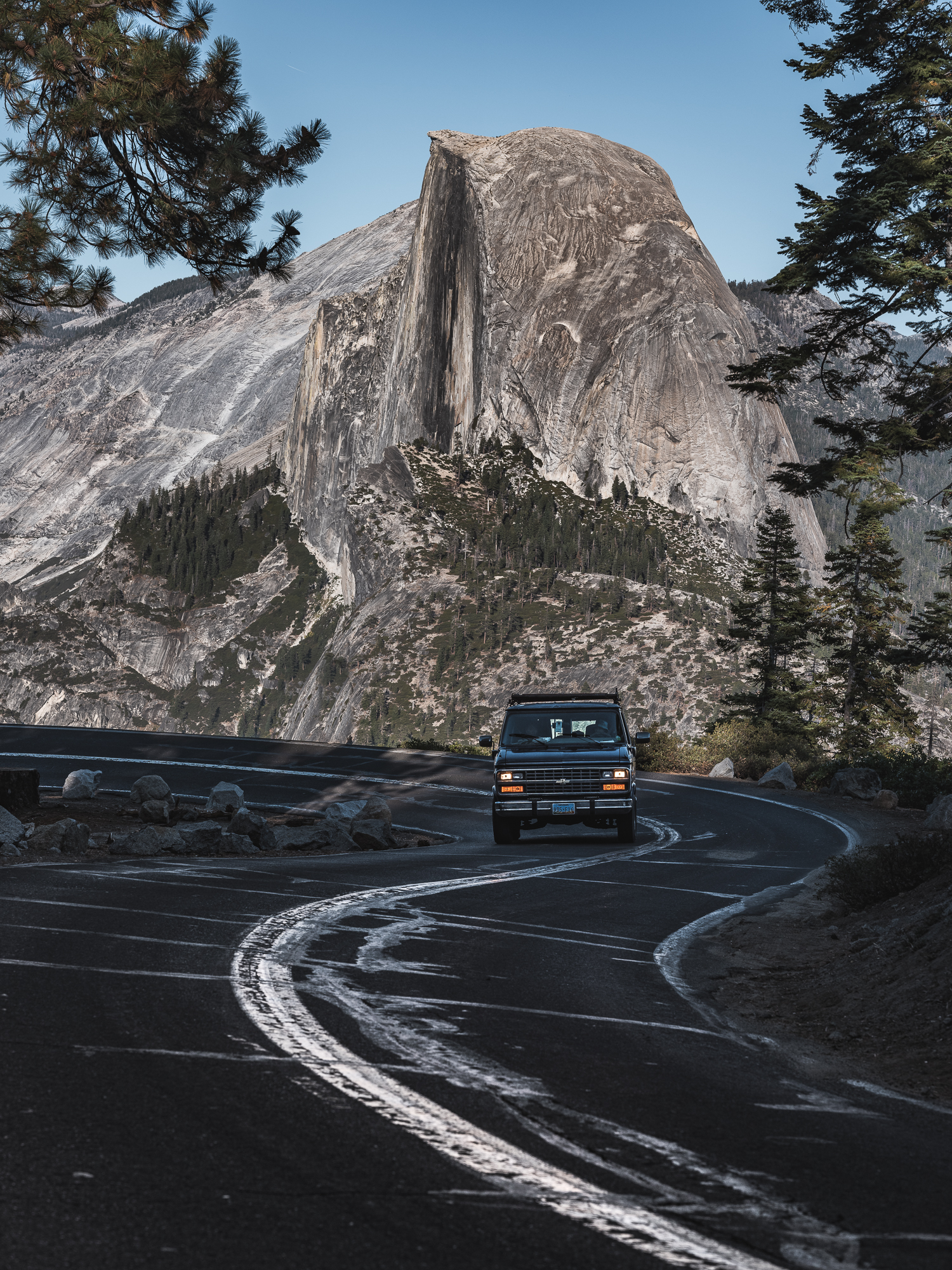 a car driving on a road with a mountain in the background