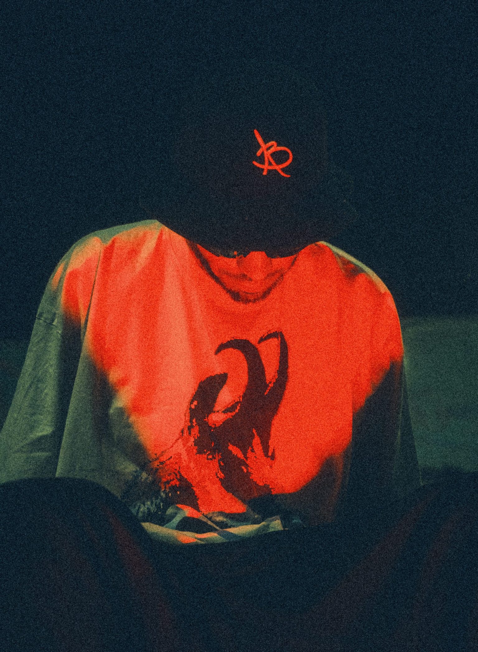 a man wearing a hat and a shirt with a red light
