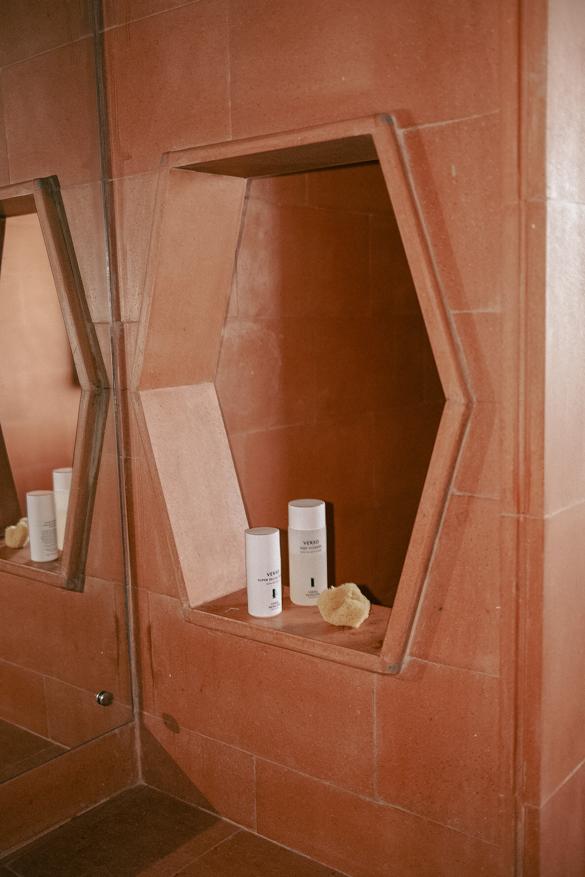 a bathroom mirror with a few white containers on a shelf
