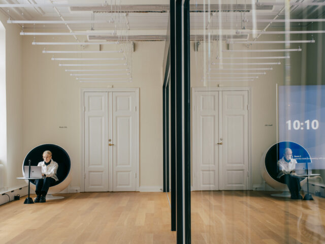 a woman sitting in a round chair in a room with doors and a white door