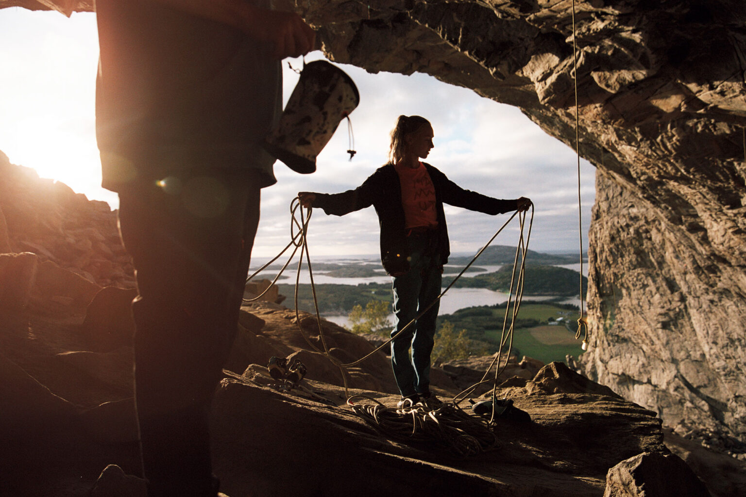 a woman standing in a cave with rope