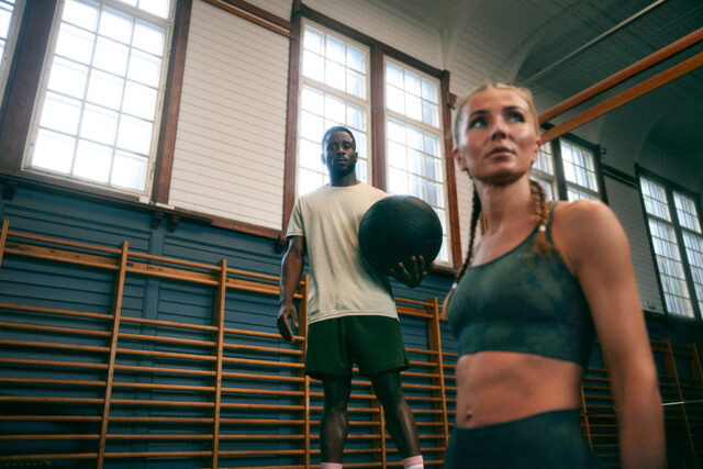 a man and woman holding a ball in a gym