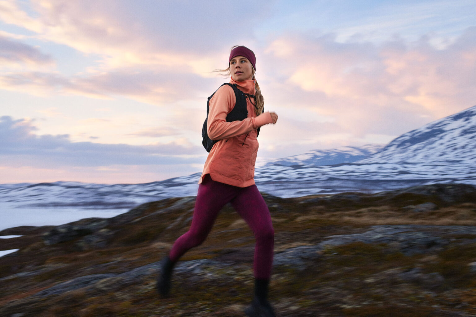 a woman running on a rocky terrain