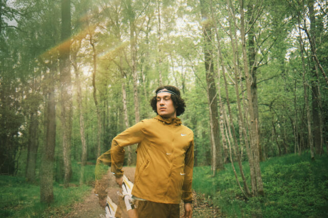 a man in a yellow jacket in a forest