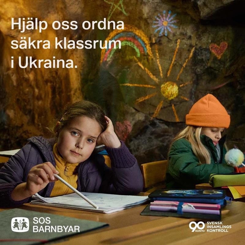 a group of children sitting at a desk