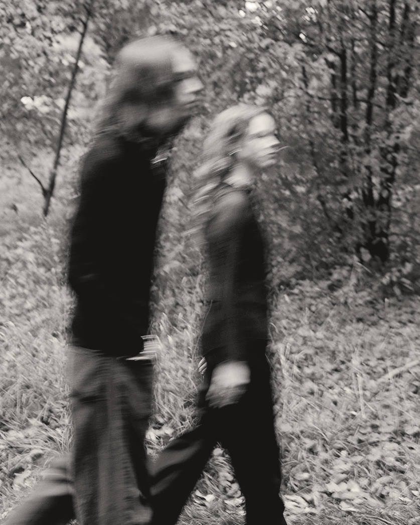 a man and woman walking in the woods