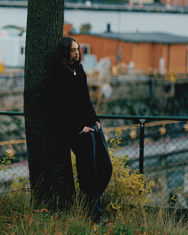 a man leaning against a tree
