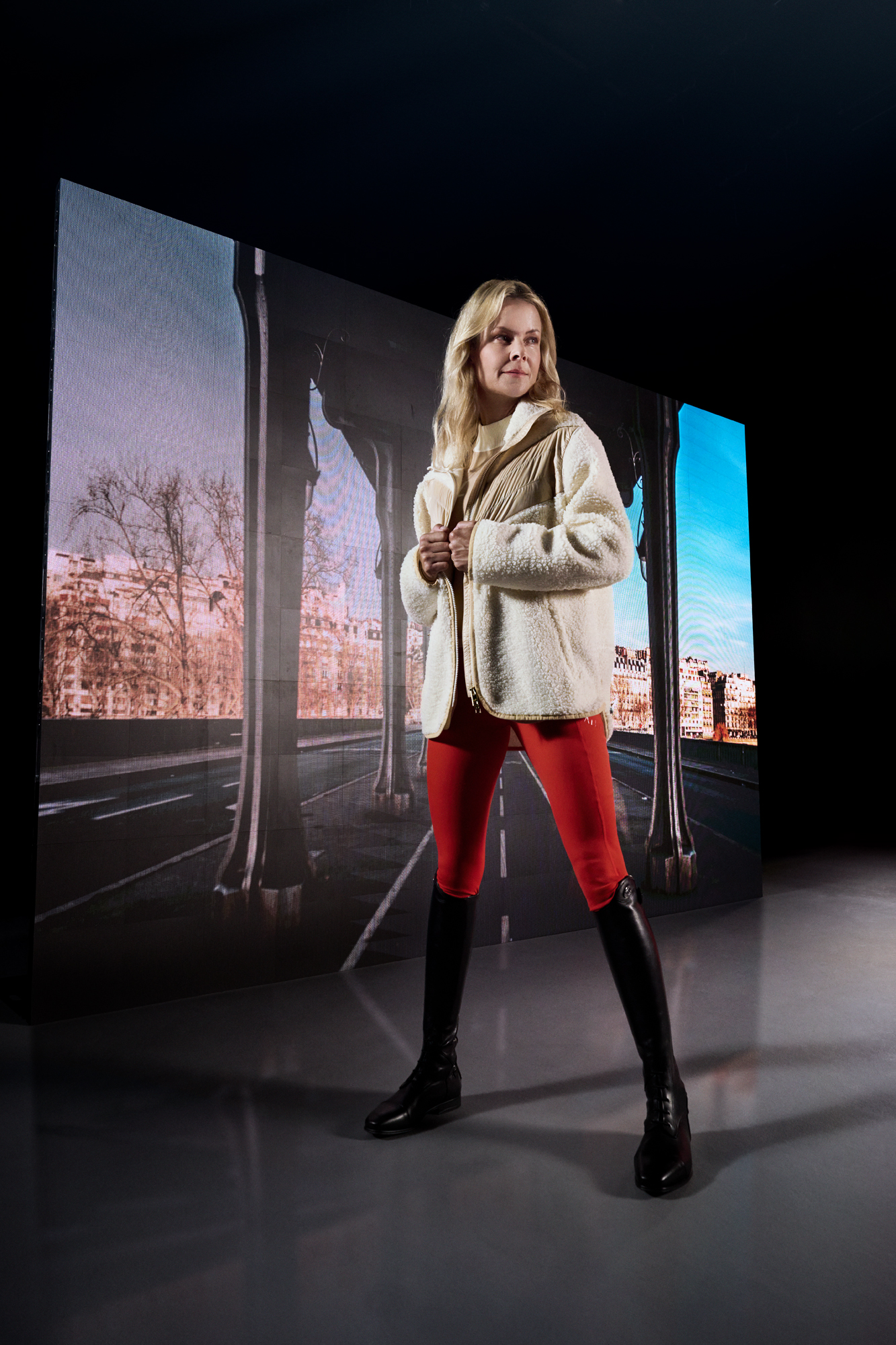 a woman standing in front of a large screen