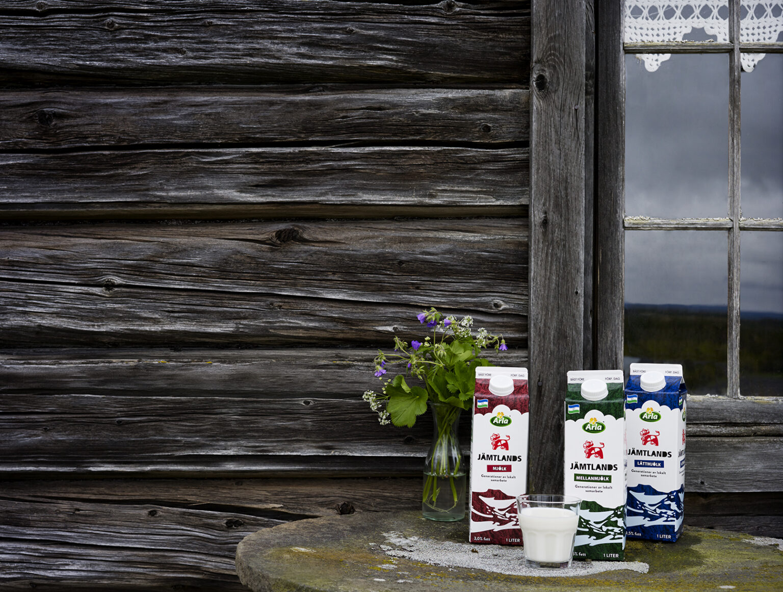 milk cartons and a glass of milk on a table