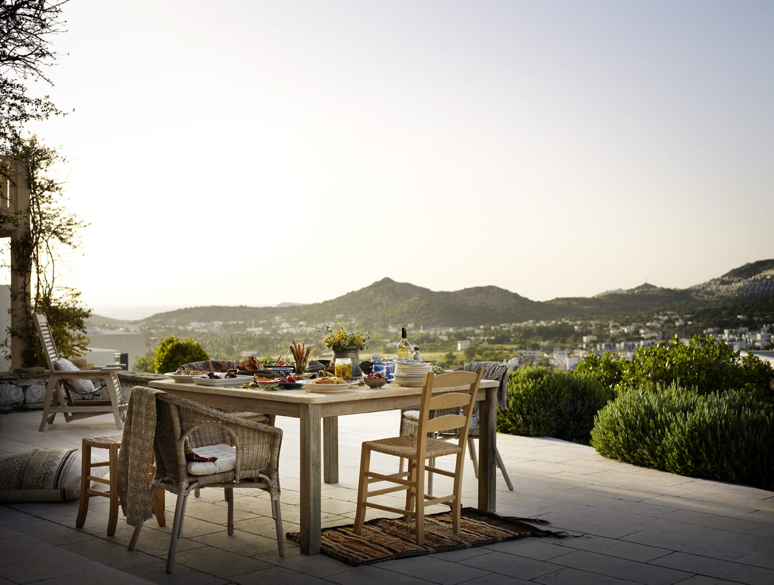 a table and chairs on a patio overlooking a city