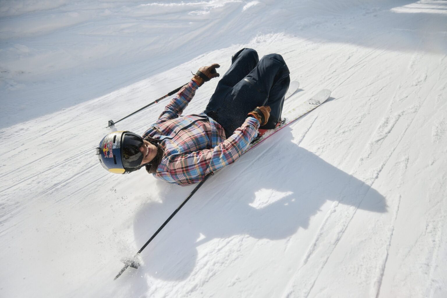 a man lying on his skis on the snow