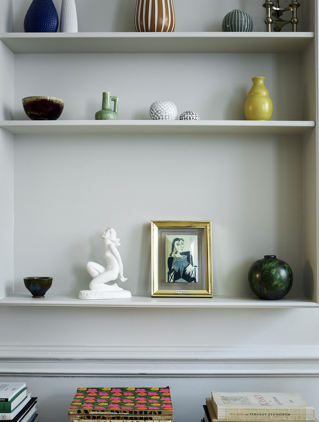 a shelf with a picture and a statue on it