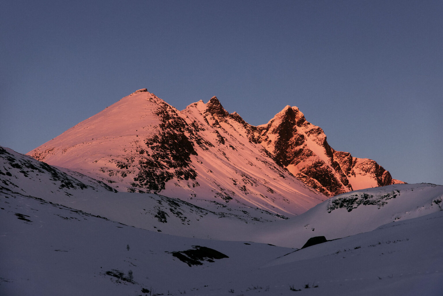 a snowy mountain with a blue sky