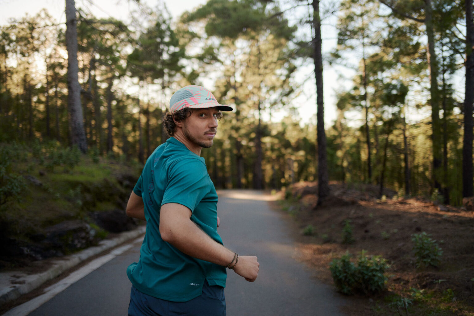 a man running on a road with trees in the background