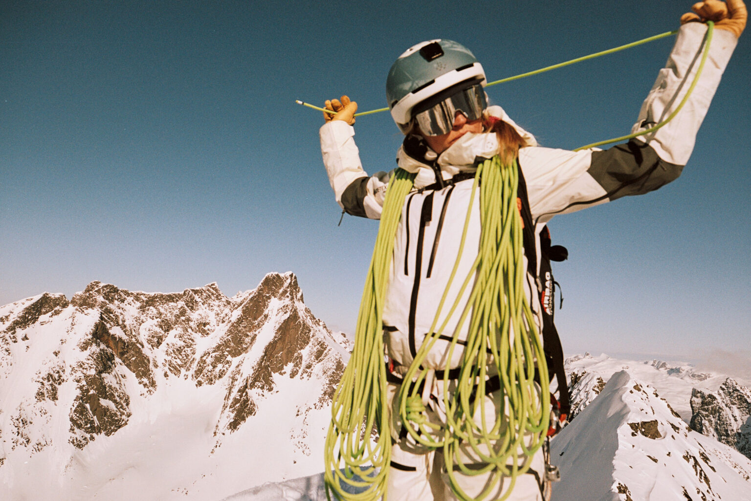a person in a helmet and goggles holding a rope