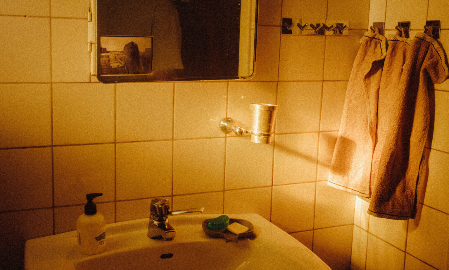 a sink with soap and a towel on the wall