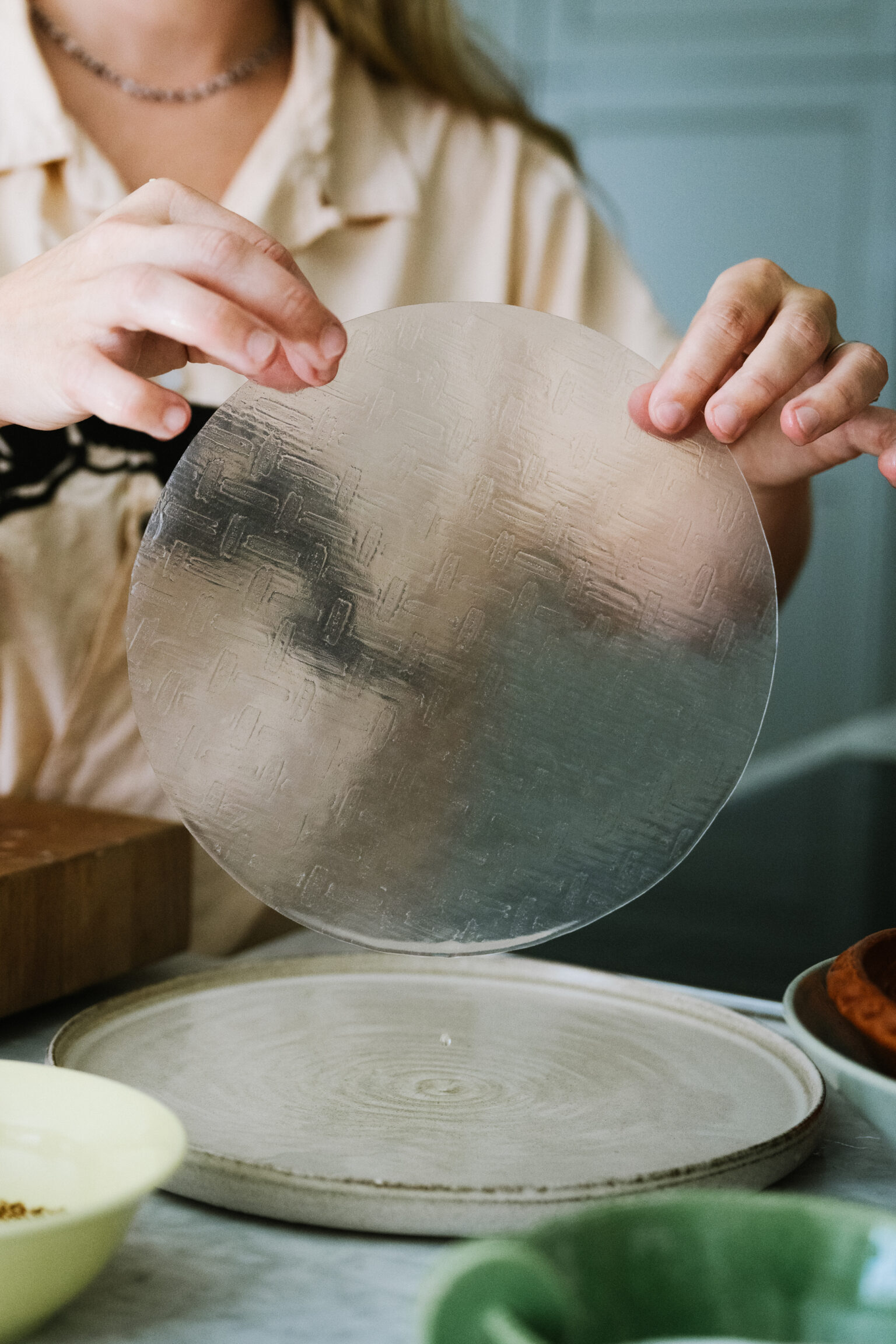 a person holding a circular object over a plate