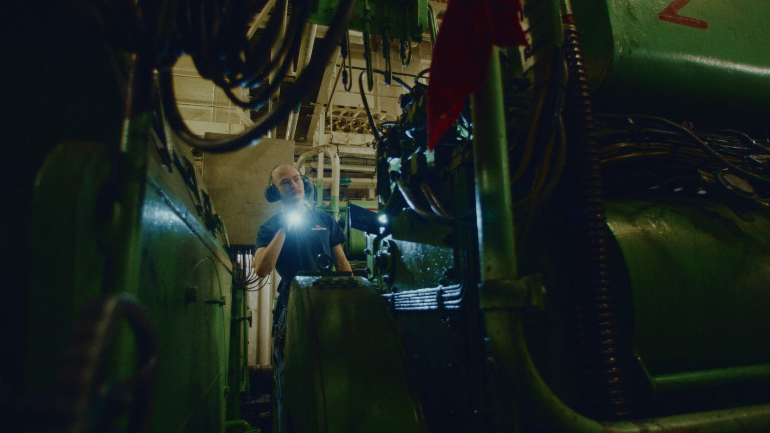 a man wearing headphones and holding a flashlight