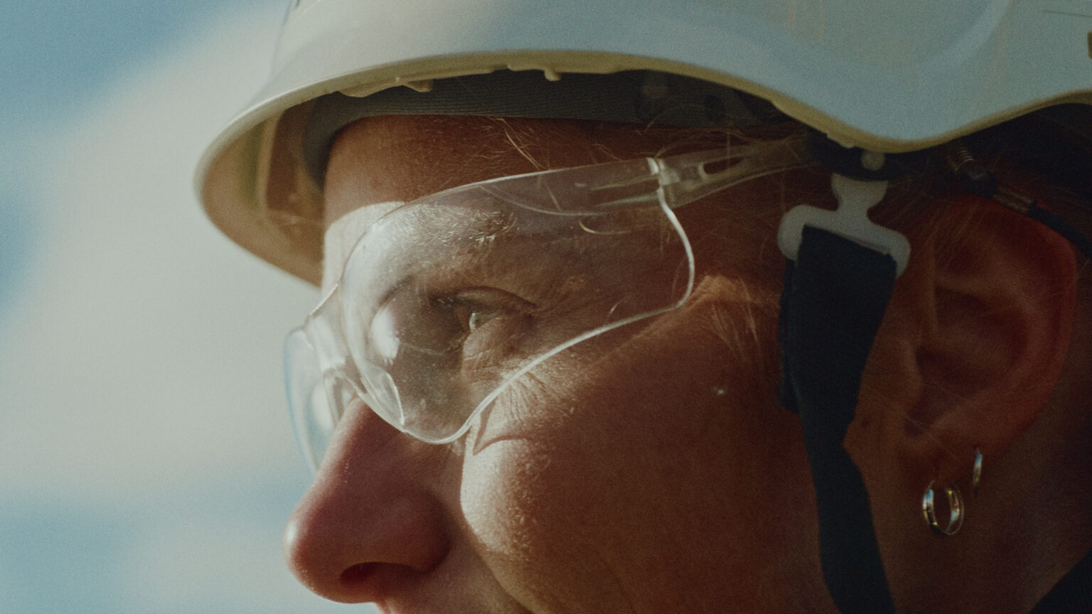 a woman wearing a hard hat and safety glasses