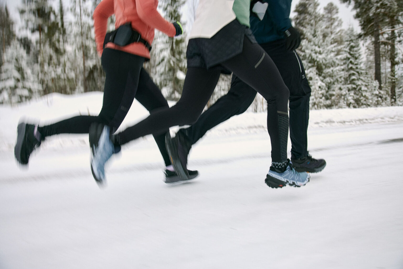 a group of people running in the snow