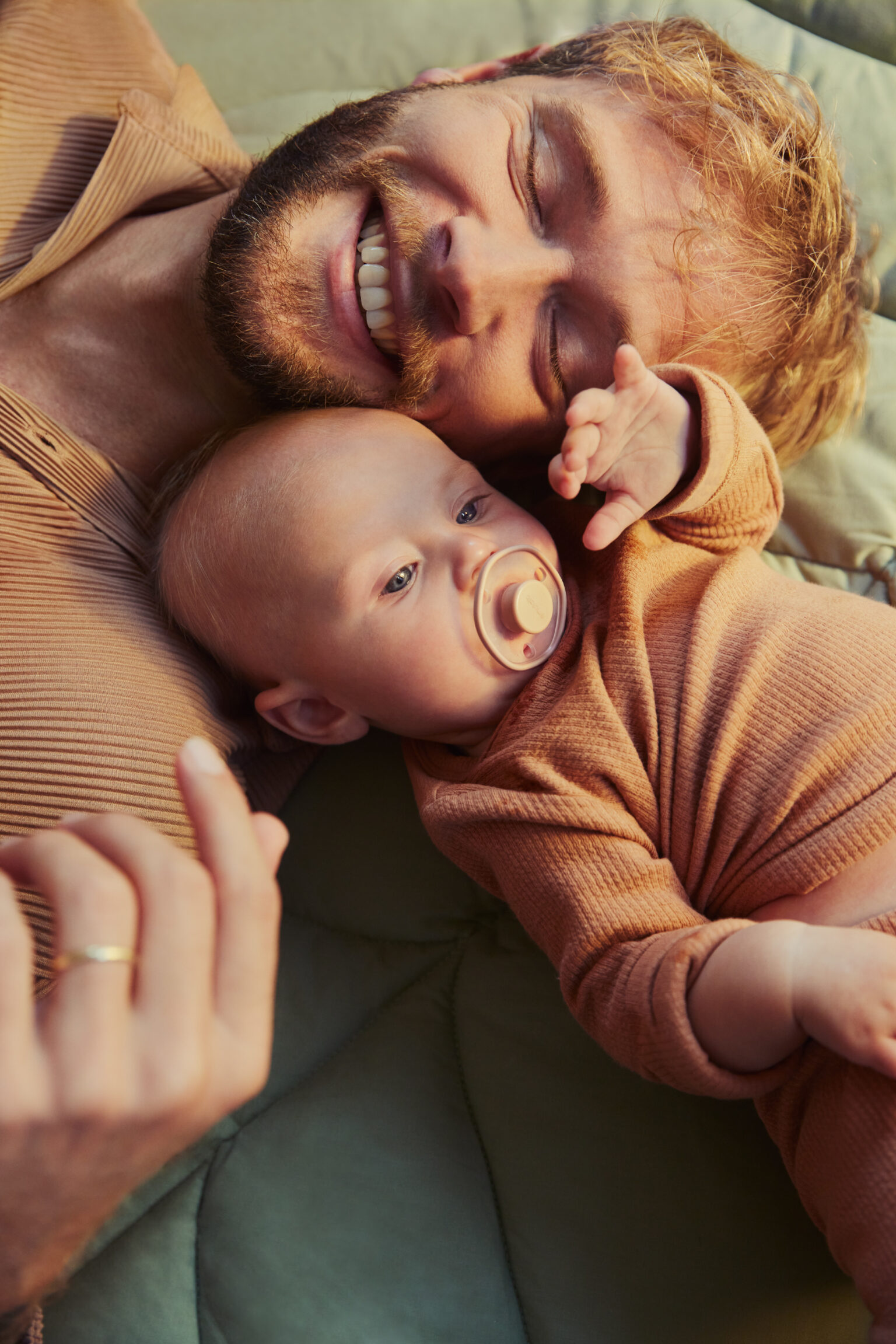 a man lying on a blanket with a baby