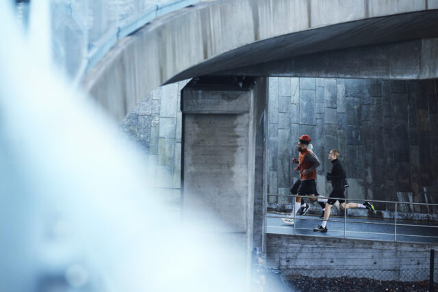 a group of people running on a bridge