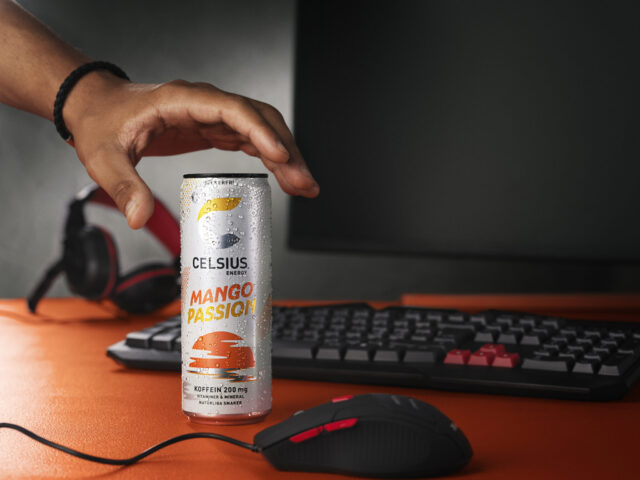 a hand reaching out to a can of mango passion