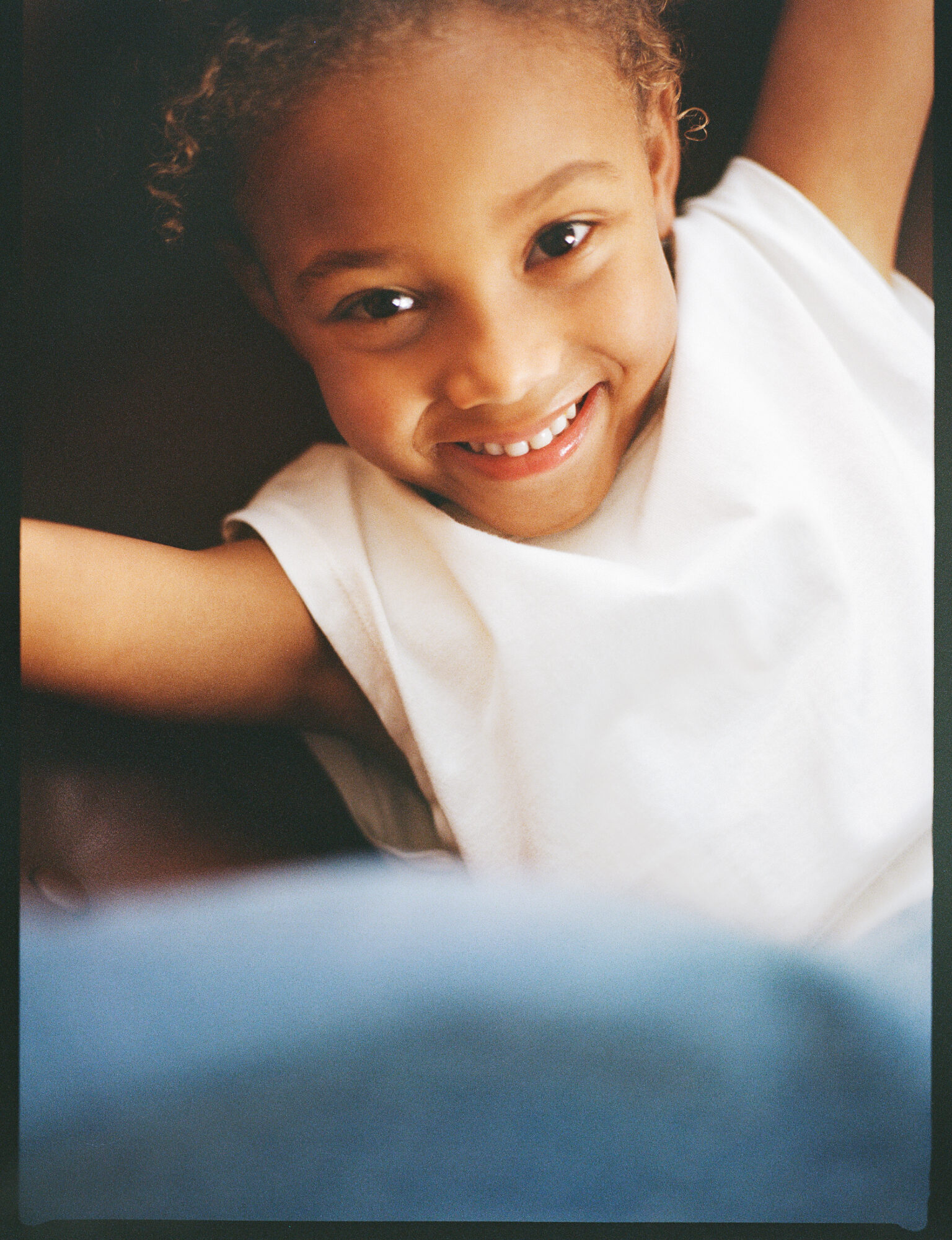 a child smiling with arms behind his back