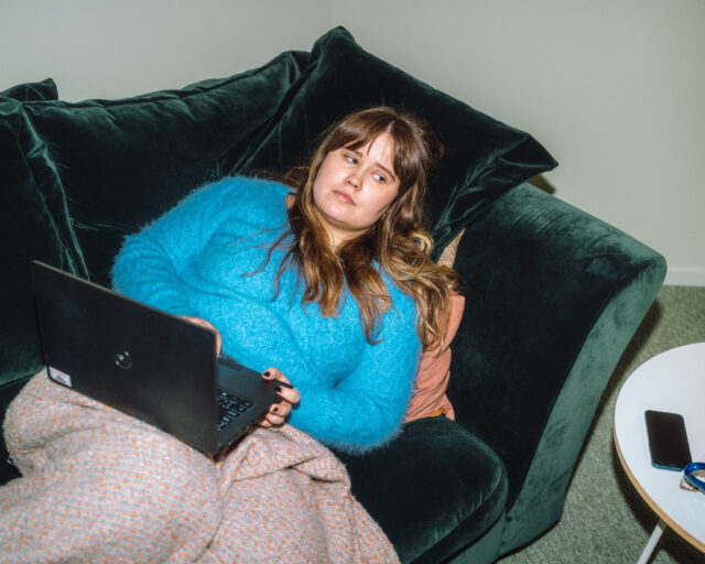 a woman sitting on a couch with a laptop