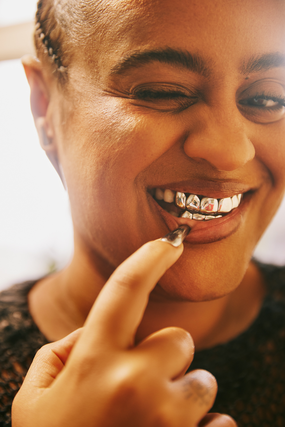 a woman smiling with gold teeth