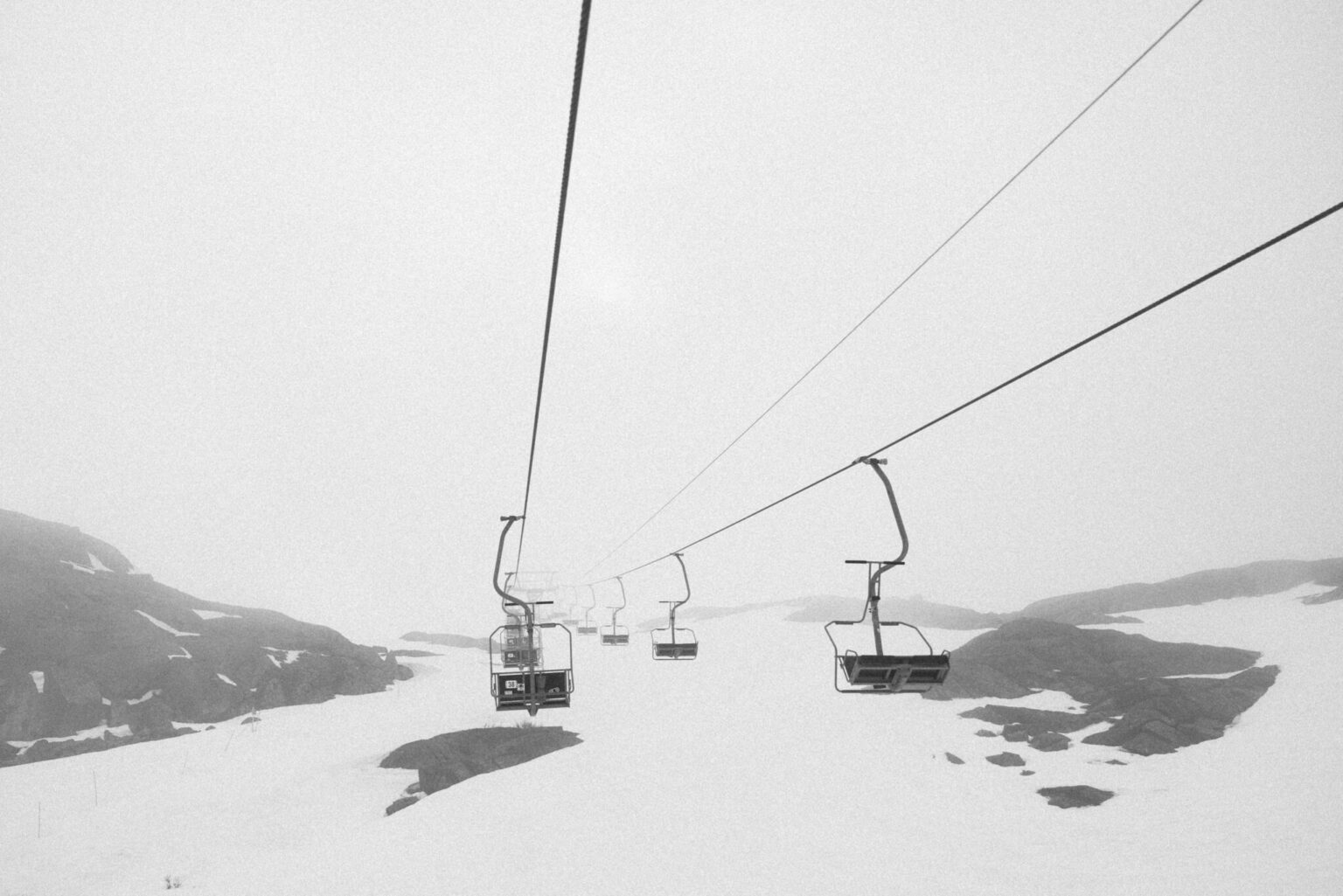 a ski lift with a group of seats on a snowy mountain