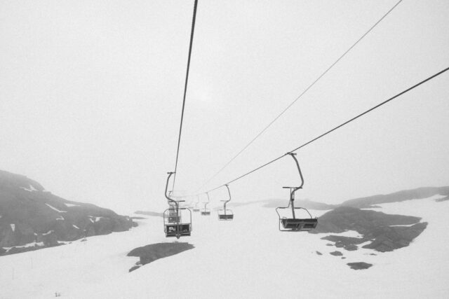a ski lift with a group of seats on a snowy mountain