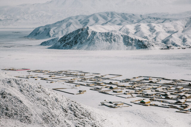 a snowy landscape with buildings and mountains