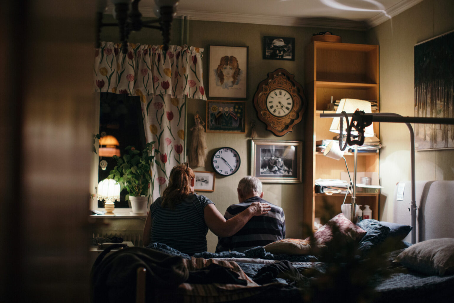 a man and woman sitting on a bed