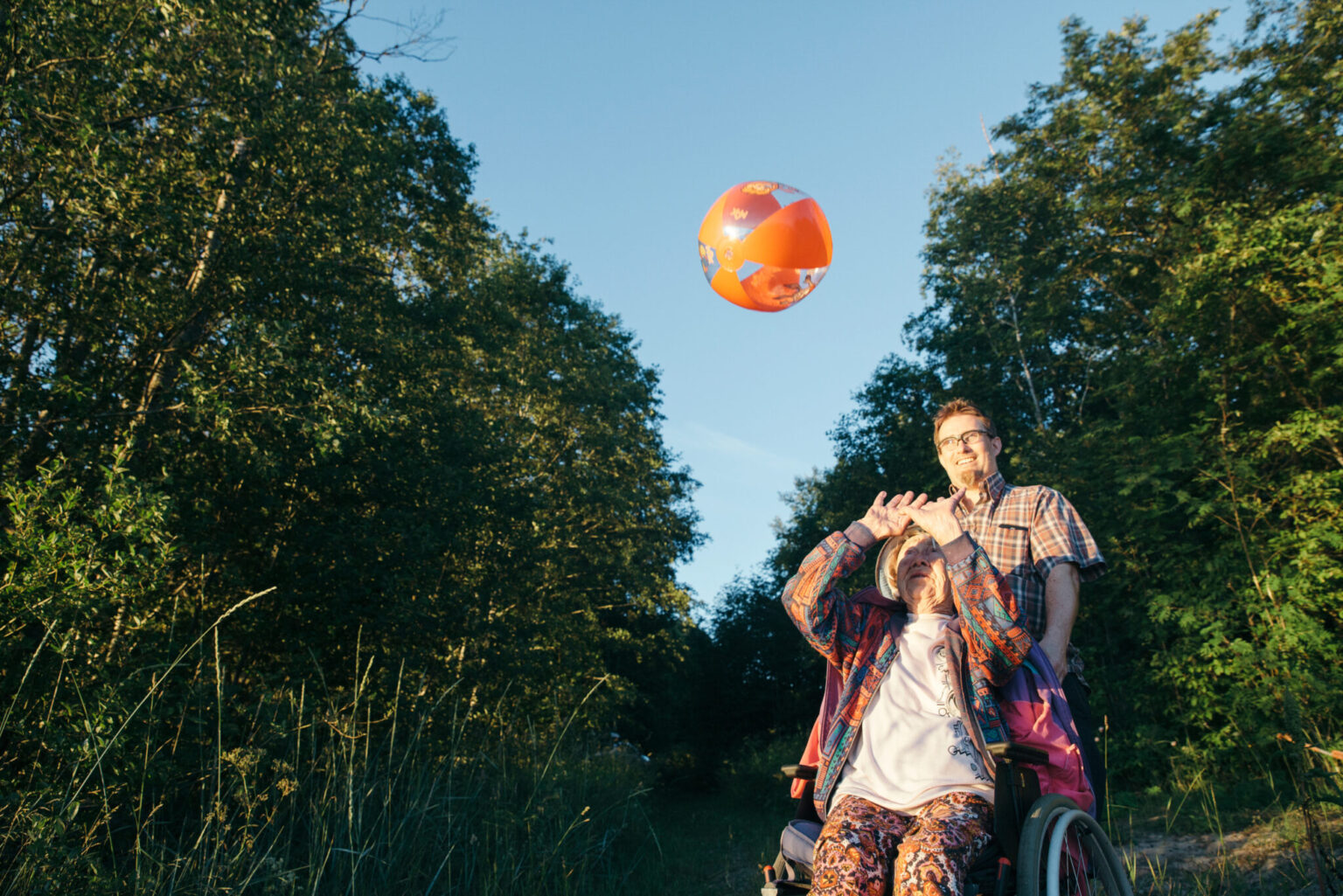 a man and woman in a wheelchair playing with a ball