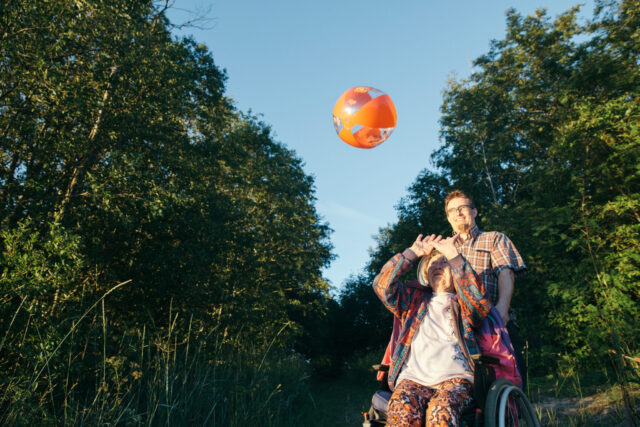 a man and woman in a wheelchair playing with a ball