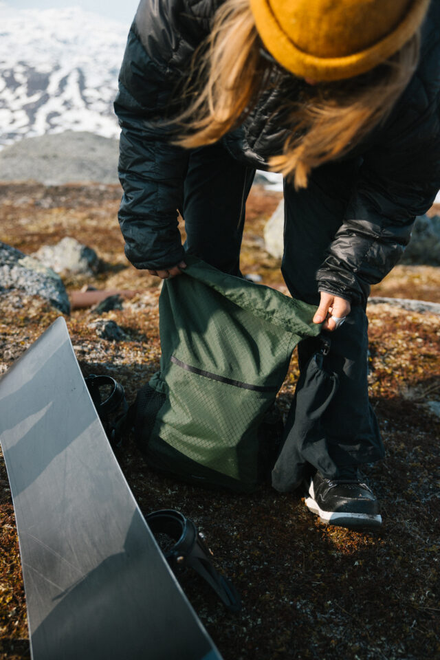 a person putting a green bag in the ground