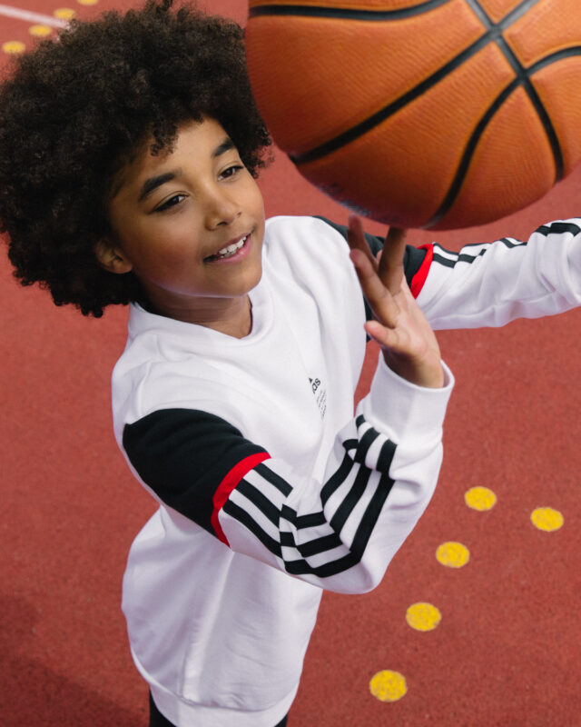 a boy spinning a basketball