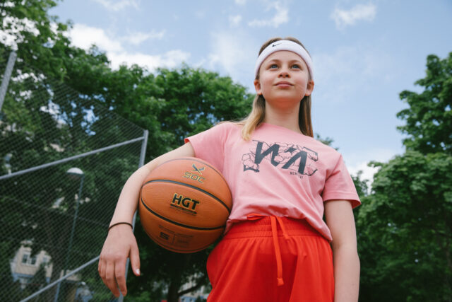 a girl holding a basketball